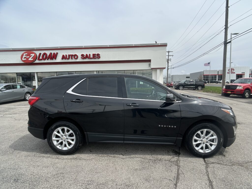 Black Chevrolet Equinox parked in front of the E-Z Loan Auto Sales showroom.