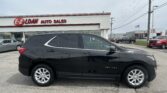 Black Chevrolet Equinox parked in front of the E-Z Loan Auto Sales showroom.