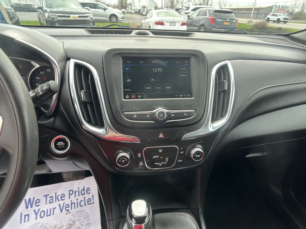 Center console of a car interior with a touchscreen infotainment display and climate controls below