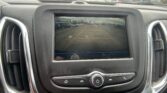 Rearview camera display showing a parking lot behind the car with orange guiding lines in the screen area.