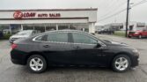Black Chevrolet Malibu sedan parked in front of E-Z LOAN Auto Sales dealership on a car lot.
