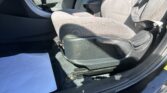 Interior of a car showing the front seats, center console, and seat belt; gear lever nearby on the floor.