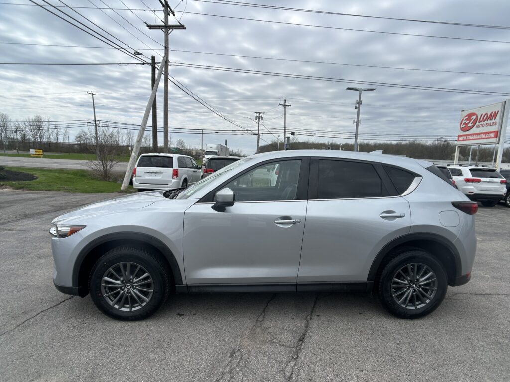 Silver SUV parked in a lot with overhead power lines and an EZ Loan Auto Sales sign in the background.