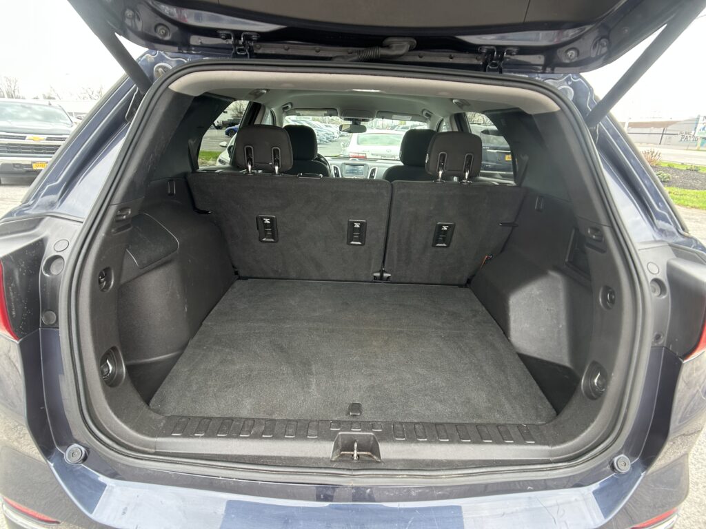 Open SUV trunk showing a spacious cargo area with the rear seats folded up and no cargo inside, view from the tailgate.