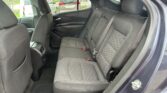 Rear passenger seats in a dark fabric car interior with center and side seatbelts visible and front seatbacks in view.
