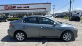 Grey sedan parked in a dealership lot with the E-Z Loan Auto Sales building in the background under a clear blue sky