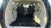 Rear interior of a minivan with the third-row seats folded down, creating a large cargo area and black floor mats.