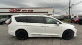 White minivan parked in front of E-Z Loan Auto Sales on a cloudy day.