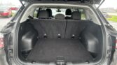 Open SUV tailgate showing spacious cargo area with rear seats upright in a parking lot