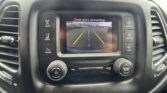 In-dash touchscreen showing a rear-view camera feed with green, yellow, and red parking lines and the message 'Check entire surroundings'.