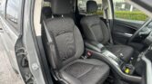 Interior of a dark gray SUV showing two front seats with textured fabric and headrests, seen from the open door