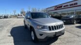 Silver Jeep SUV in the foreground at an auto dealership lot, with the E-Z Loan Auto Sales building to the right.