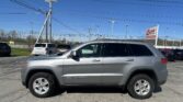 Gray SUV in a parking lot with a tall utility pole and numerous power lines overhead; EZ Loan Auto Sales sign in the background.