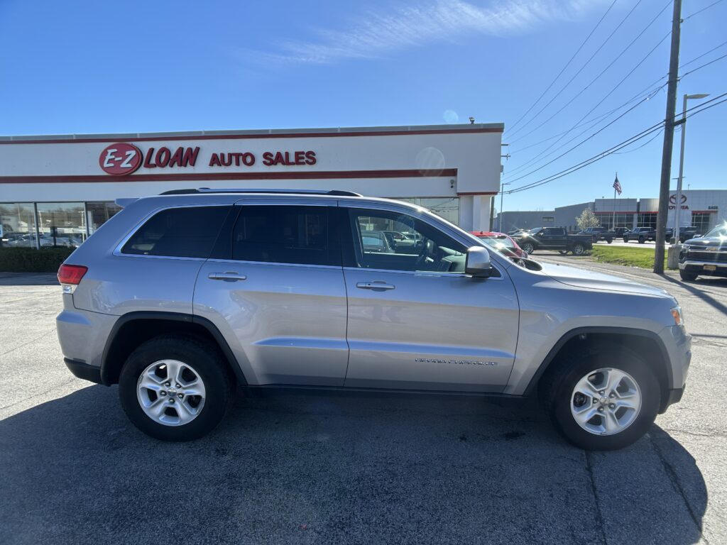 Silver SUV parked in front of EZ Loan Auto Sales on a sunny day, with the storefront visible in the background.