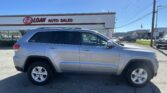 Silver SUV parked in front of EZ Loan Auto Sales on a sunny day, with the storefront visible in the background.