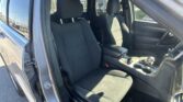 Open driver-side door view of a SUV interior with black fabric seats, center console, and gear shifter.