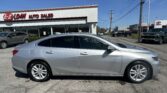 Silver sedan parked in front of the E-Z Loan Auto Sales dealership on a sunny day.