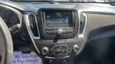 Driver's-seat view of the dashboard with a center touchscreen showing 550 AM and climate controls, plus a 'We Take Pride In Your Vehicle!' flyer on the floor.