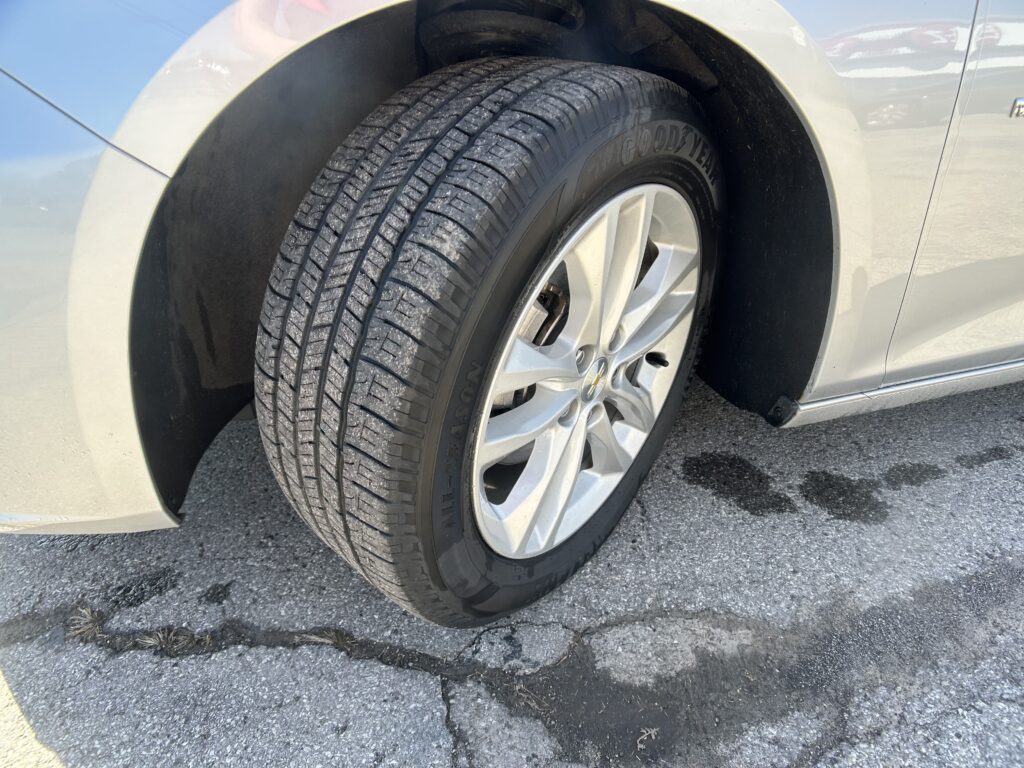 Close-up of a car’s front tire and silver alloy wheel, showing the tread pattern and Goodyear branding.