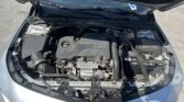 Open car hood showing engine bay with an Ecotec engine cover, battery on the right, and various hoses and components visible.