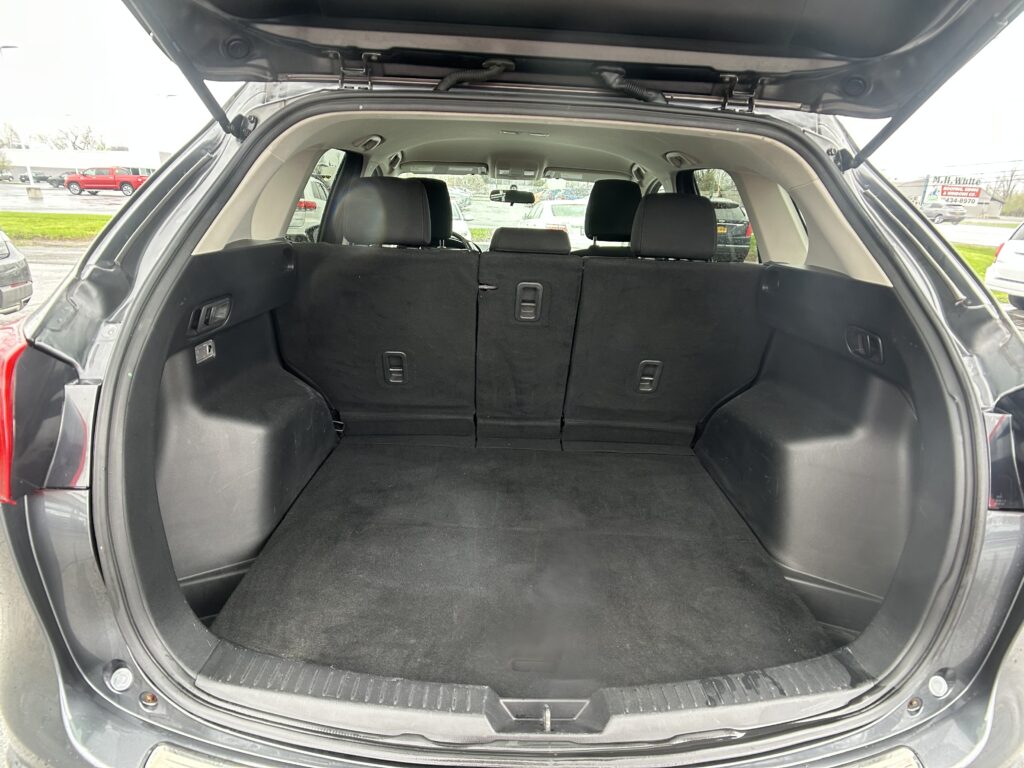 Open SUV trunk showing spacious cargo area with folded/fold-down rear seats and black interior upholstery.