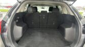 Open SUV trunk showing spacious cargo area with folded/fold-down rear seats and black interior upholstery.