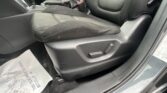 Front interior of a dark sedan with two black cloth seats, center console, and a floor protecting sheet partially visible near the door.