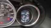 Close-up of a car dashboard showing the speedometer and a digital display with outside temperature (55°F) and trip readout.