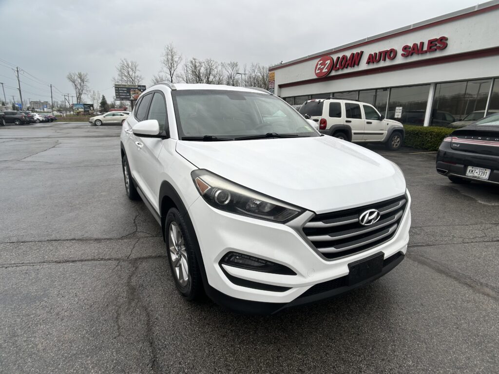 White Hyundai SUV in a parking lot with EZ Loan Auto Sales storefront in the background.