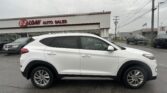 White SUV parked in foreground at EZ Loan Auto Sales lot with dealership building in background and American flag nearby.