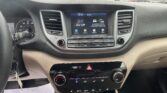 Car dashboard center console with touchscreen showing 'AV Off' and menu icons, surrounded by climate controls and vents outside.