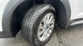 Close-up of a car wheel and tire in the wheel well, showing the tread pattern and alloy rim.