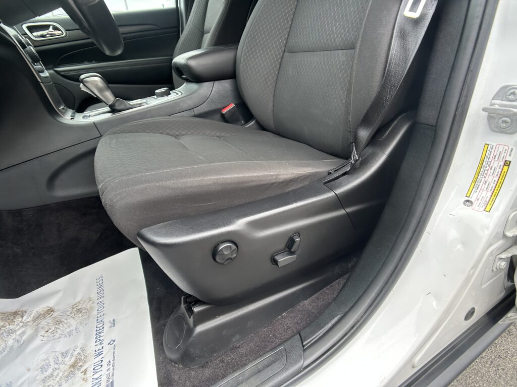 Interior of a car showing the front seats, center console, and gear shifter with a seat belt visible on the right side of the image.