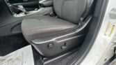 Interior of a car showing the front seats, center console, and gear shifter with a seat belt visible on the right side of the image.