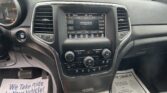 Interior of a car showing the center touchscreen and climate controls with a paper on the floor reading 'We Take Pride In Your Vehicle'.