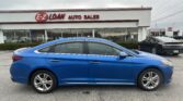 Blue sedan parked in front of an auto dealership with a prominent E-Z LOAN AUTO SALES sign on the building and a Toyota dealership in the background.