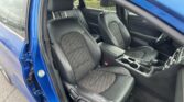 Blue car interior with black leather seats, front and rear, and a center console visible in the cabin view.