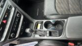 Interior of a car showing the center console with gear shifter, cupholders, and climate controls; passenger seat and a 'SONATA' floor mat visible on the floor.
