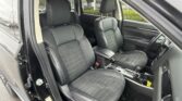 Front seats in a black leather car interior with a center console and gear shifter visible in the cabin.