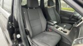 Front and rear passenger seating area in a black SUV with dark cloth seats and a center console visible between them? (front seats in view)