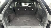 Car trunk with rear seats upright and a carpeted cargo floor, empty and ready for loading.