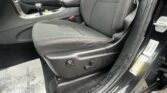 Front interior of a car showing the center console, gear shifter, and passenger seat with scattered papers on the floor area.