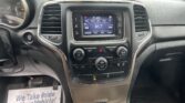 Car dashboard with center touchscreen showing FM radio and 91.7, flanked by climate controls and side vents. The driver-side gauge cluster is visible to the left.