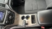 Interior view of a car showing the center console with climate controls, cupholders, and gear shifter between front seats.