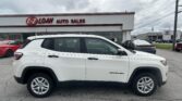 White SUV parked in front of E-Z LOAN AUTO SALES dealership with other cars and the sign visible in the background.