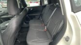 Interior of a grey SUV back seat row with three black fabric seats, headrests, and visible seat belts; front seats and door panels also visible.