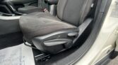Front interior of a car showing the front passenger seat, center console with a gear shifter, and armrest in dark upholstery with contrast stitching.