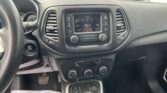 Interior view of a car showing the steering wheel, center touchscreen, climate controls, and gear shifter, with a flyer on the floor that reads 'We Take Pride In Your Vehicle'.