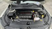 Open hood of a white SUV showing the engine bay with a black engine cover labeled '2.4L multiair'. The battery and various components are visible on the right.