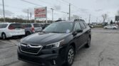 Dark SUV in a car dealership lot with an EZ LOAN AUTO SALES sign in the background on a cloudy day